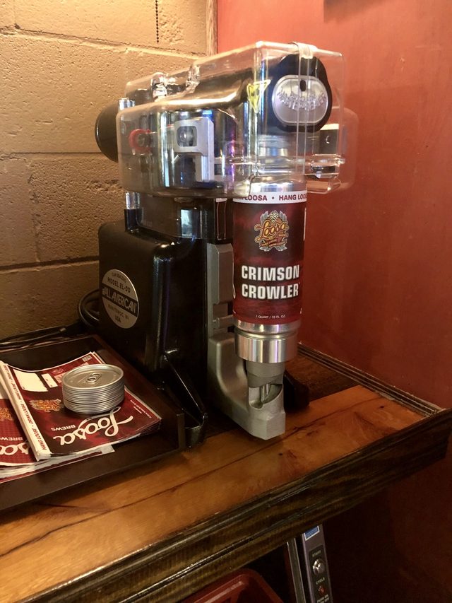 A Crimson Crowler can locked into the seaming machine behind the bar, ready to be sealed